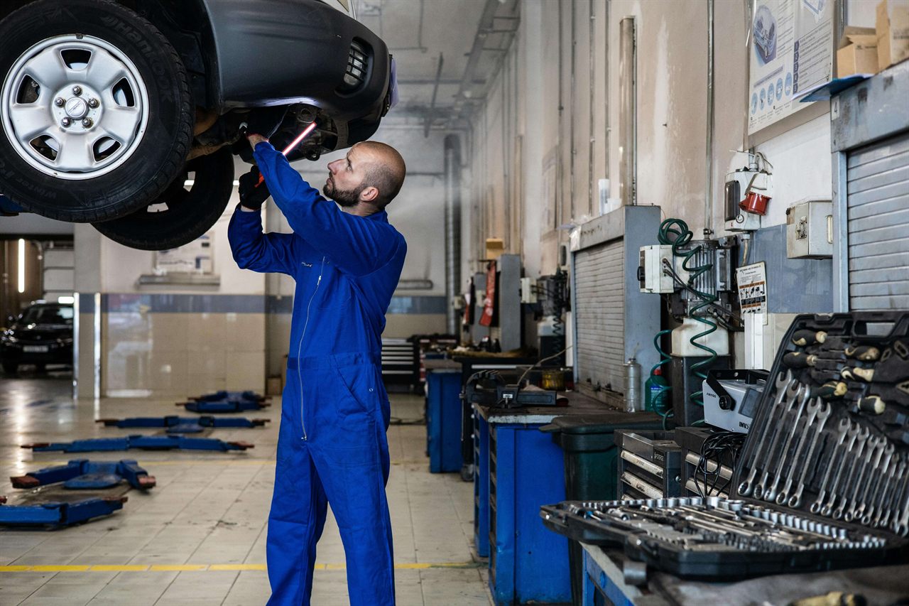 Mecanic auto reparând o mașină pe elevator în atelierul Service Auto Năvodari, Constanța
